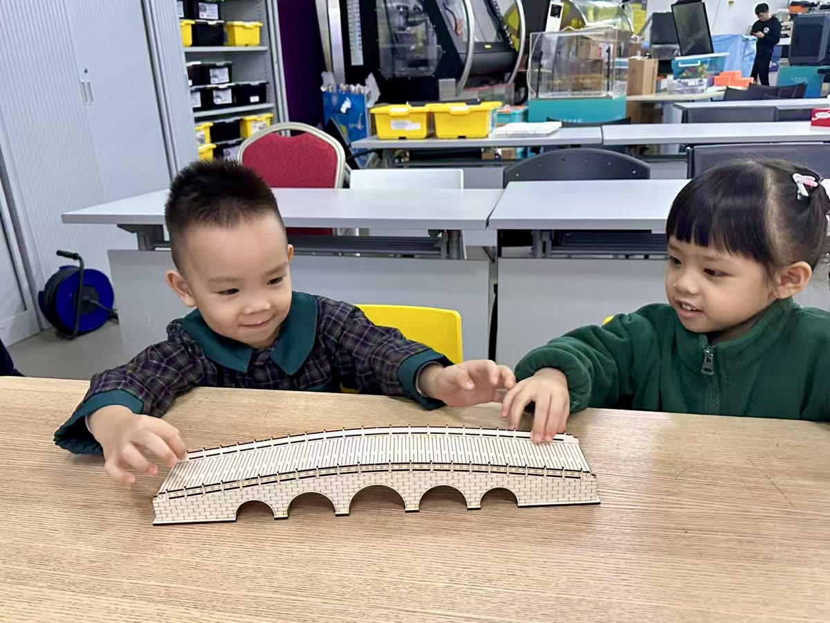 兩名幼兒合作建構積木橋